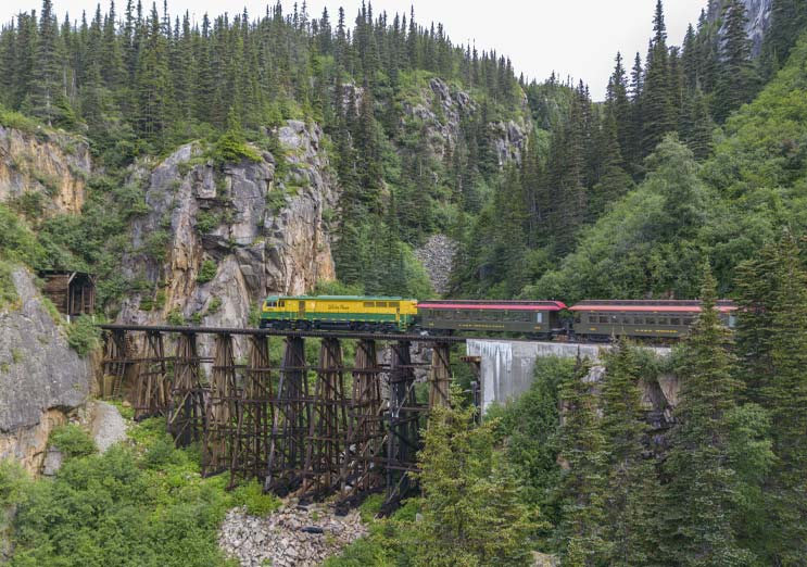 Alaska Train Shore Excursion, train coming down tracks with tunnel mountain in the distance