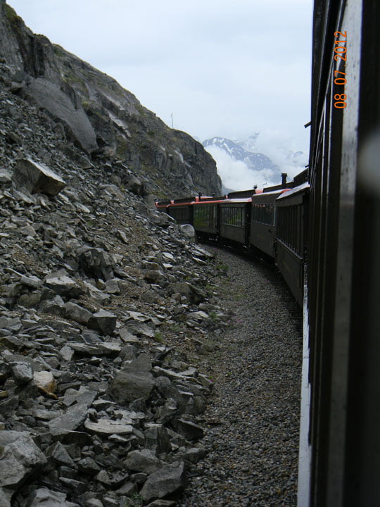 Train is disappearing into a mountain - by dan cohen